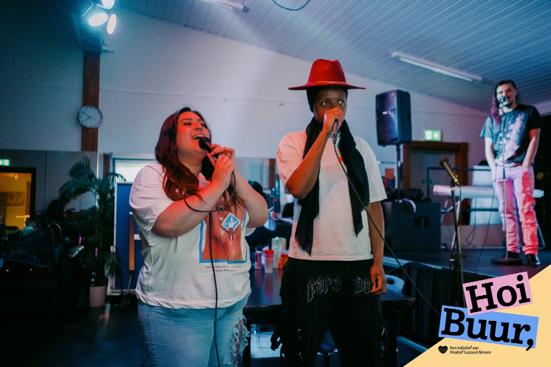 Twee deelnemers zingen enthousiast samen tijdens een gezellige Karaoke Jam in Almere, waar muziek en plezier mensen samenbrengen. Een activiteit van Hoi Buur Almere.