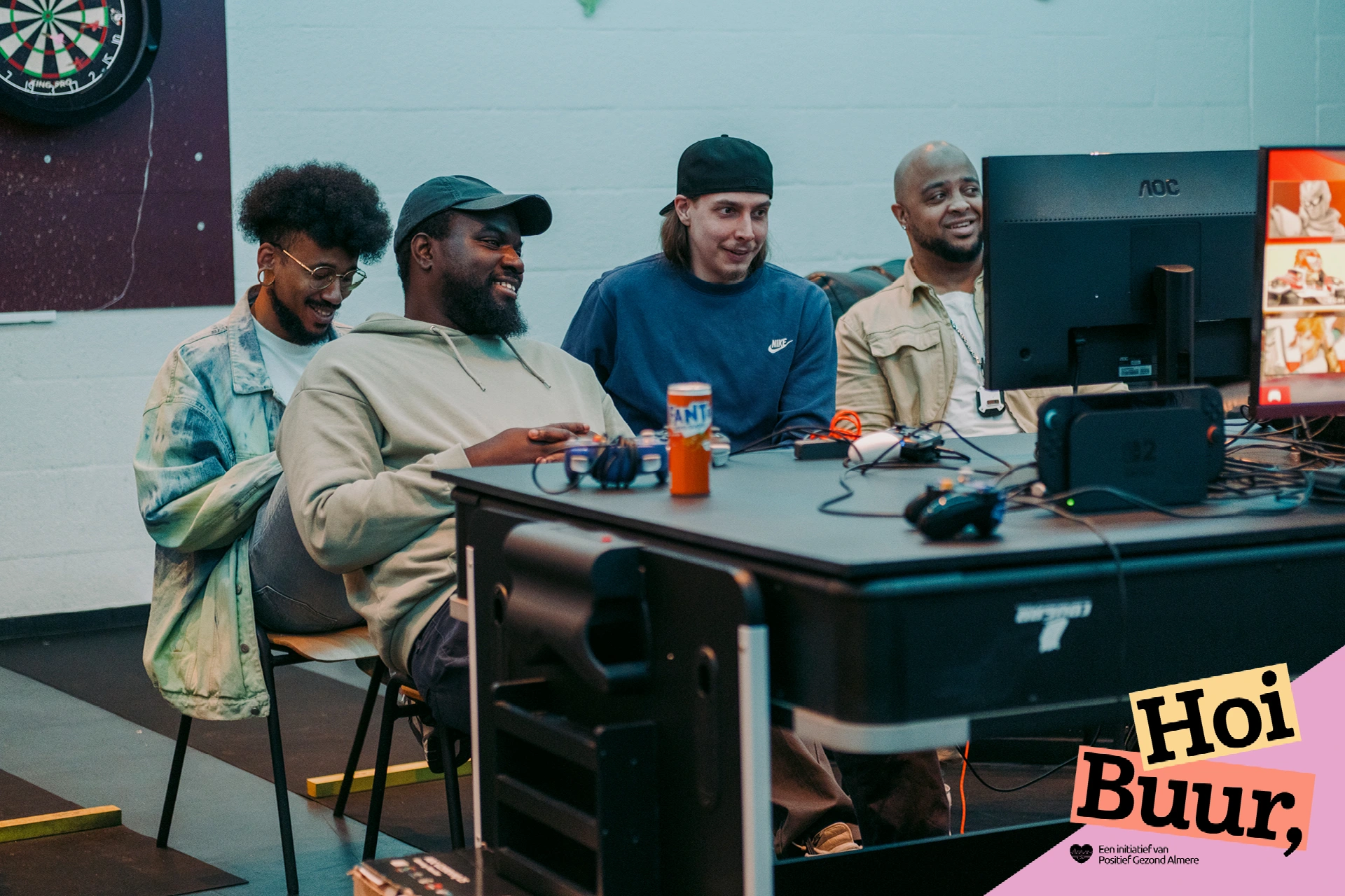 Vier deelnemers spelen samen videogames bij Smash Lounge in Almere. Een gezellige ontmoetingsactiviteit van Hoi Buur Almere.