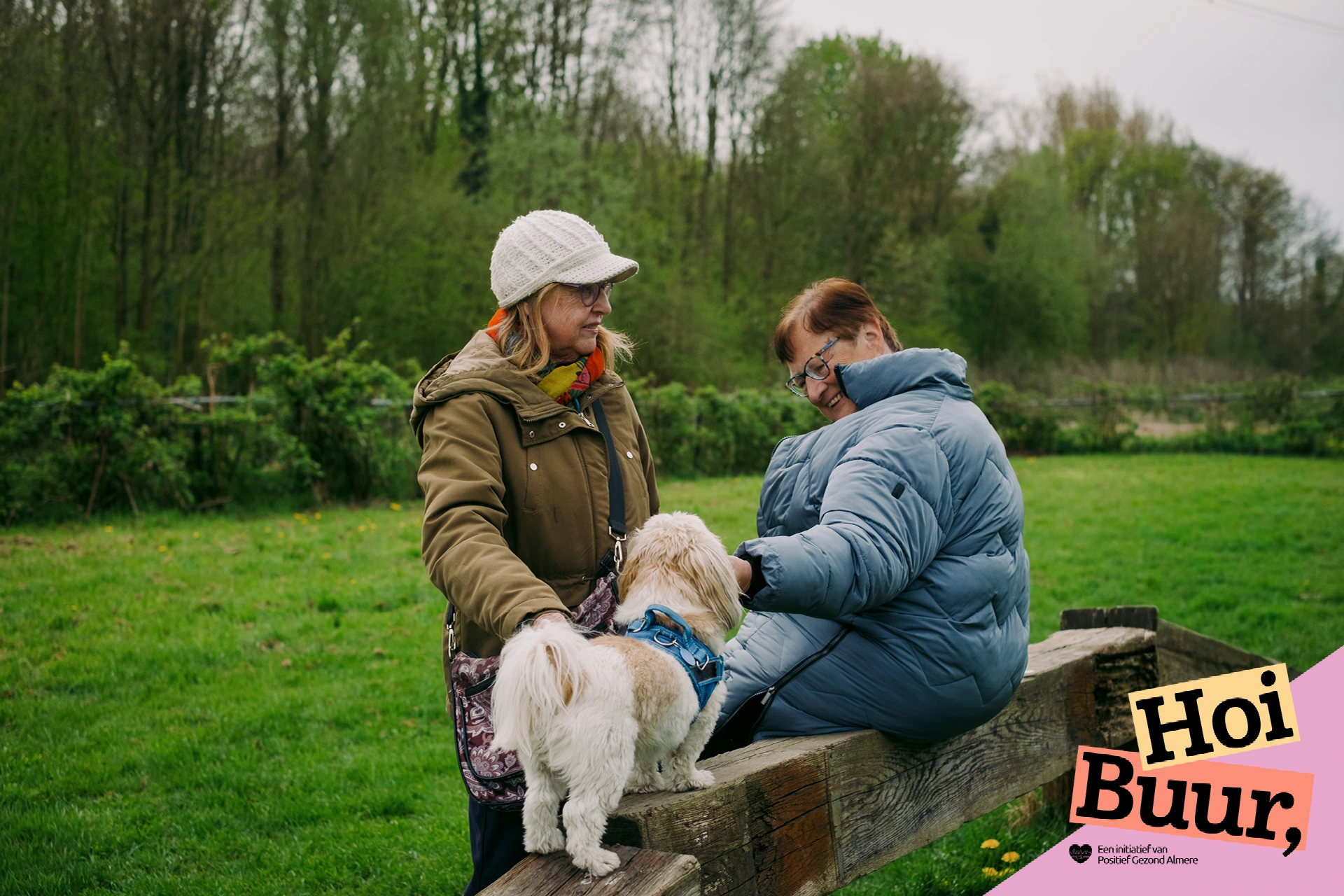 Twee deelnemers ontmoeten elkaar met hun honden tijdens het Hondencafé in Almere, een gezellige activiteit van Hoi Buur Almere.